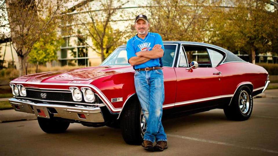 Doug Crouch standing beside a classic car.